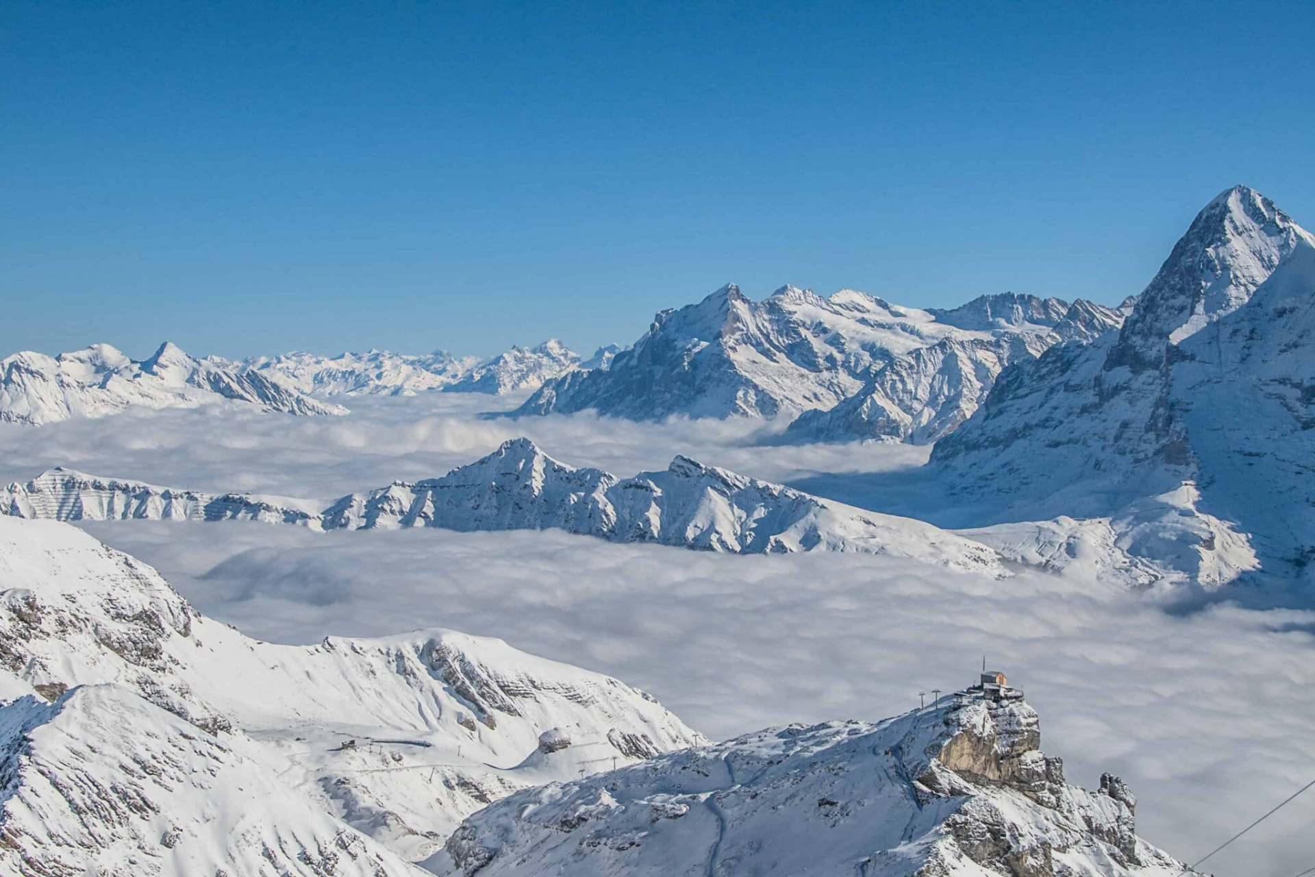 Snow-covered alpine peaks above a sea of clouds